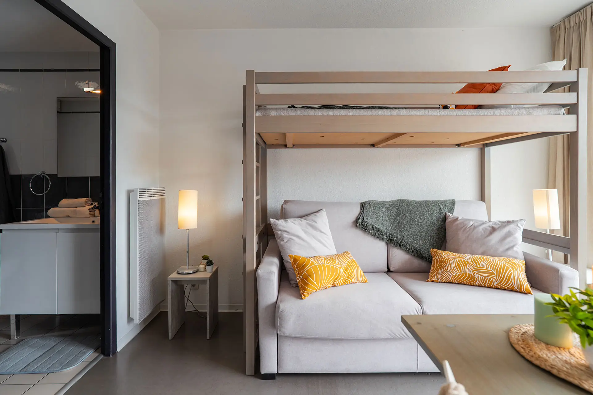 Studio avec animaux admis à Hossegor, idéal pour un séjour proche de la plage centrale. Intérieur du studio avec lit en hauteur et canapé converible et décoration moderne à Soorts-Hossegor