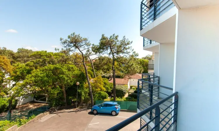 Vue de la terrasse du premier étage avec vue sur le parking et la nature à deux pas de l'océan