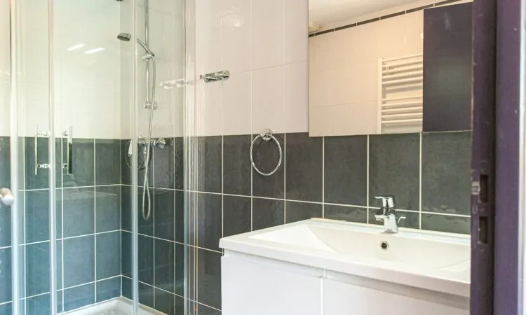 Miroir au-dessus du lavabo dans la salle de bain avec douche et WC du studio de la Plage Centrale