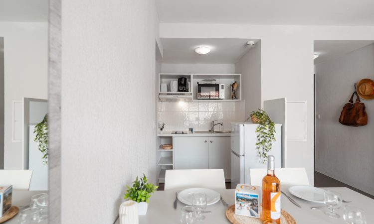 T2 standard avec table à manger et aménagement simple. Coin déjeuner d’un T2 standard bien intégré au séjour.