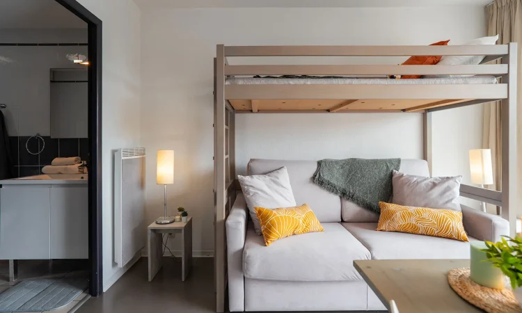 Studio avec animaux admis à Hossegor, idéal pour un séjour proche de la plage centrale. Intérieur du studio avec lit en hauteur et canapé converible et décoration moderne à Soorts-Hossegor