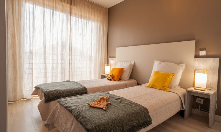 Deuxième chambre d’un T3 prestige avec décoration élégante et confort optimal. Chambre d’appoint lumineuse dans un appartement T3 prestige.