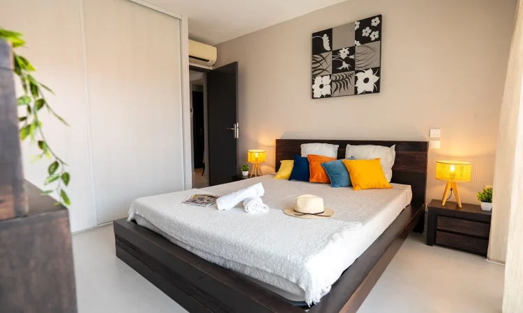 Chambre parentale spacieuse dans un T3 luxe. Espace nuit calme et soigné. Chambre moderne avec décoration apaisante.