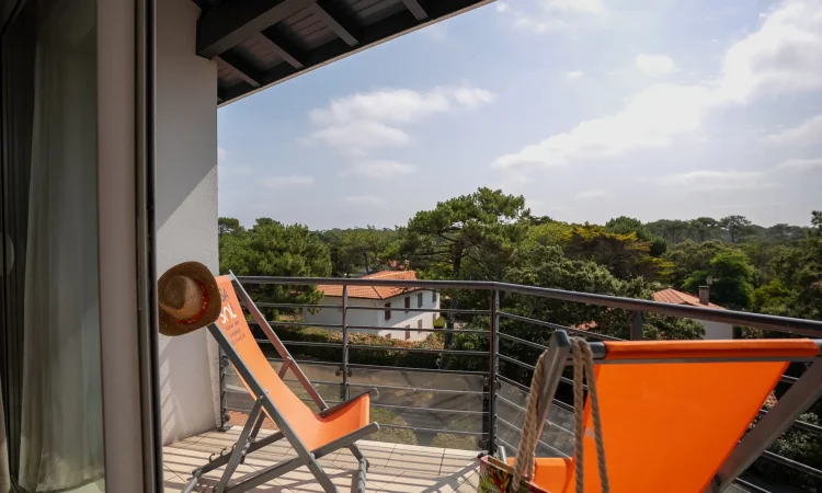 Terrasse patio loggia d'un quartier calme du T3 luxe de la plage centrale avec vue sur les toits et la végétation environnante.