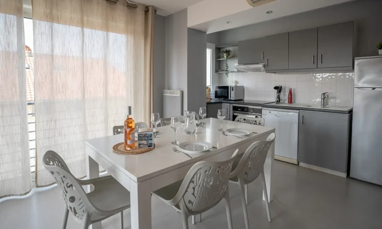 Cuisine équipée d’un T3 luxe avec finitions modernes. Espace repas élégant, cuisine fonctionnelle et haut de gamme avec table à manger.